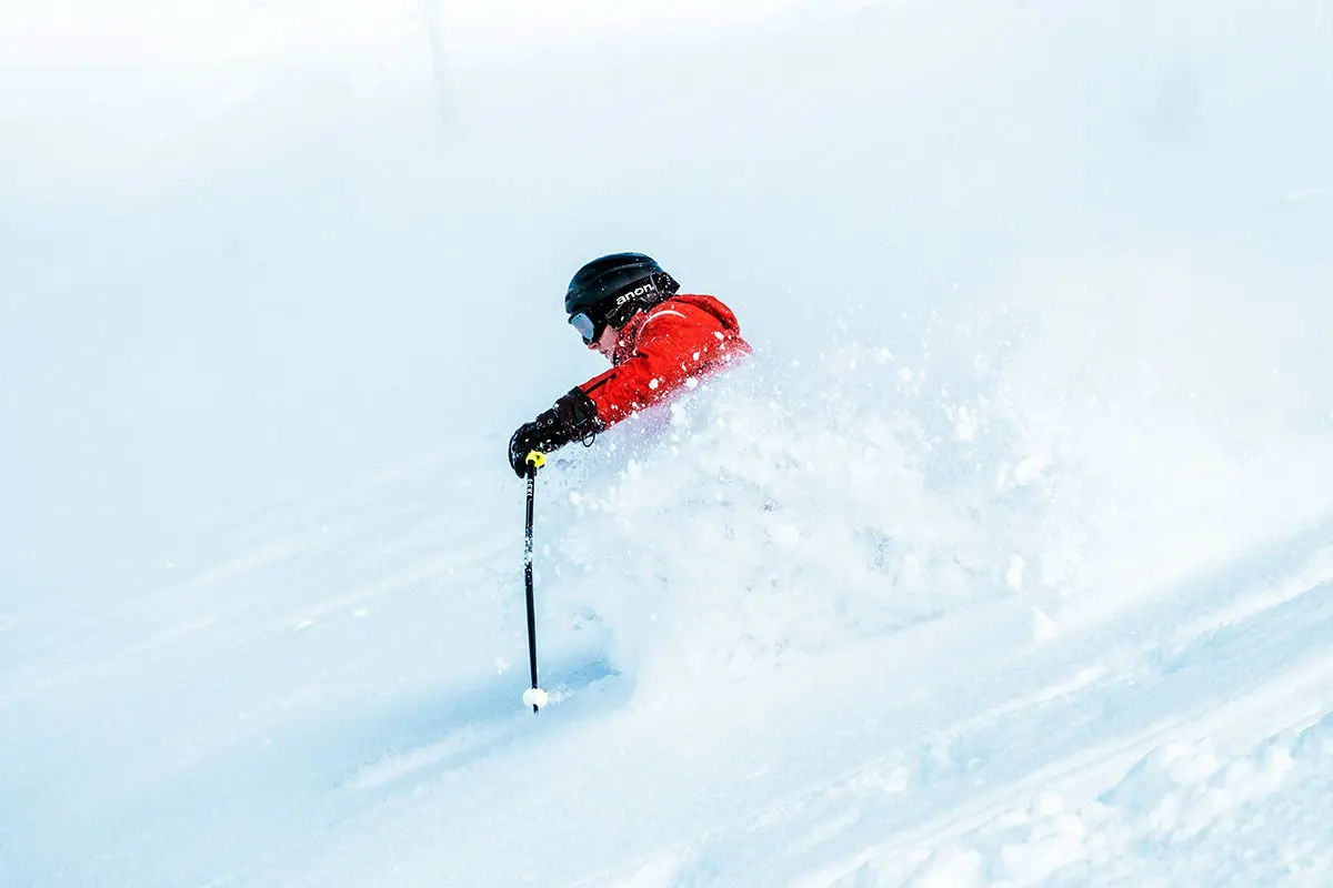 Skier in Red Jacket Skiing Through Powder Snow in Neukirchen Am Grossvenediger, Austria. Photo by Maarten Duineveld, Unsplash.