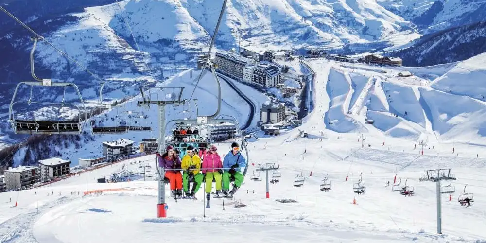 Vue panoramique de Saint Lary Soulan avec une famille dans une remontée mécanique