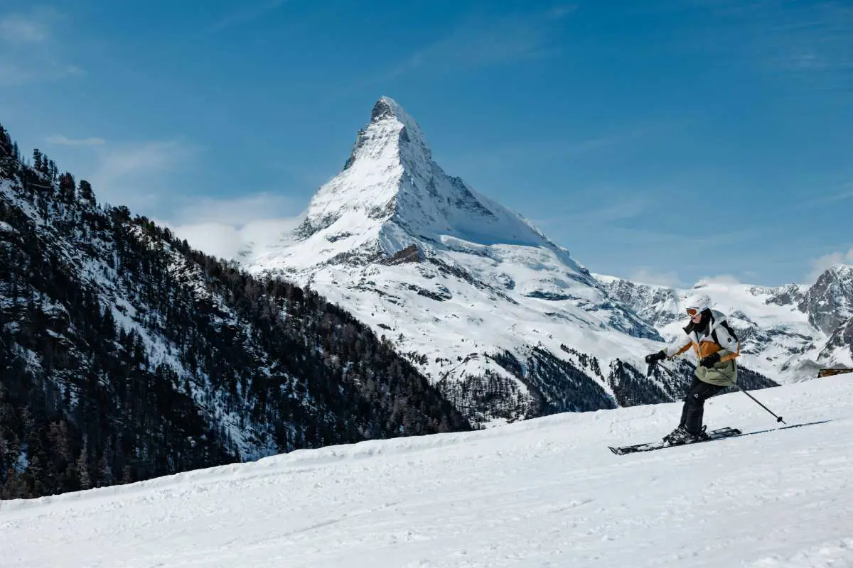 Skier enjoying a clear blue sky on a piste at Zermatt ski resort, Switzerland with the Matterhorn in the background. Photo by Krzysztof Kowalik from Unsplash