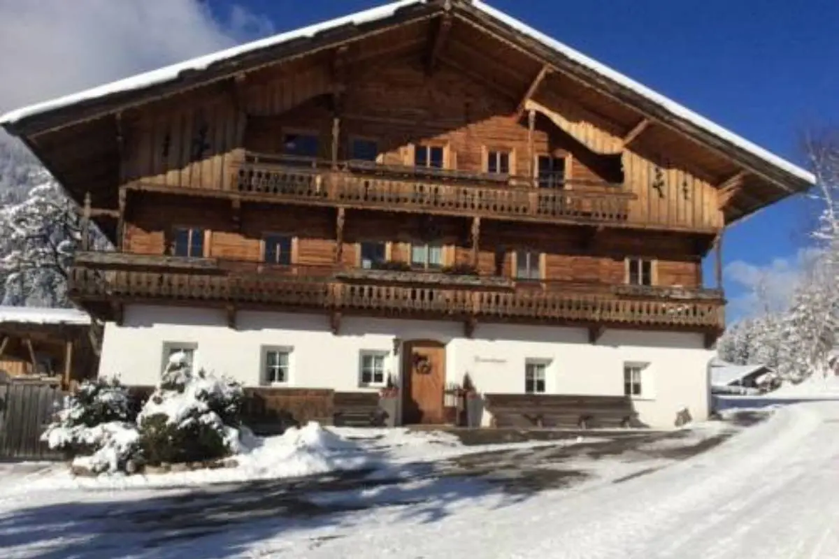 Hotel Bauernhaus Franzlhof surrounded by snow on a clear day in SkiWelt.