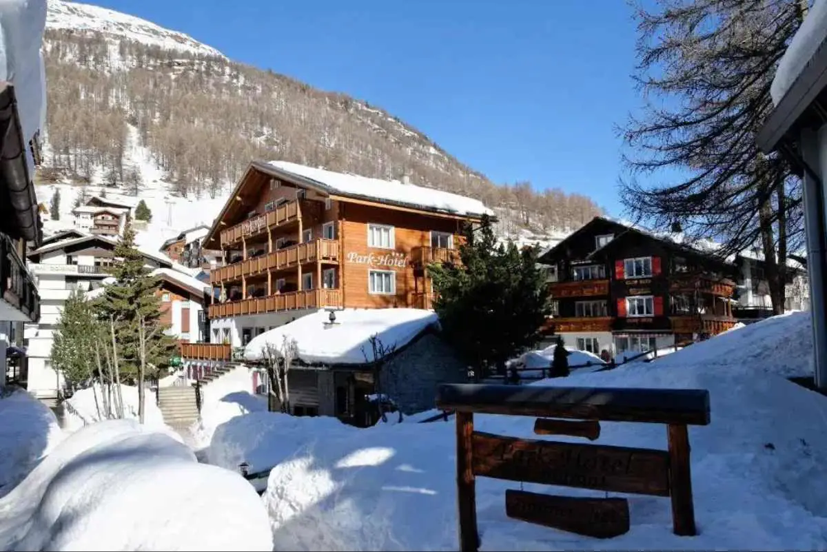 Park Hotel, Saas-Fee Switzerland covered by a light dusting of snow on a bright blue sky day.