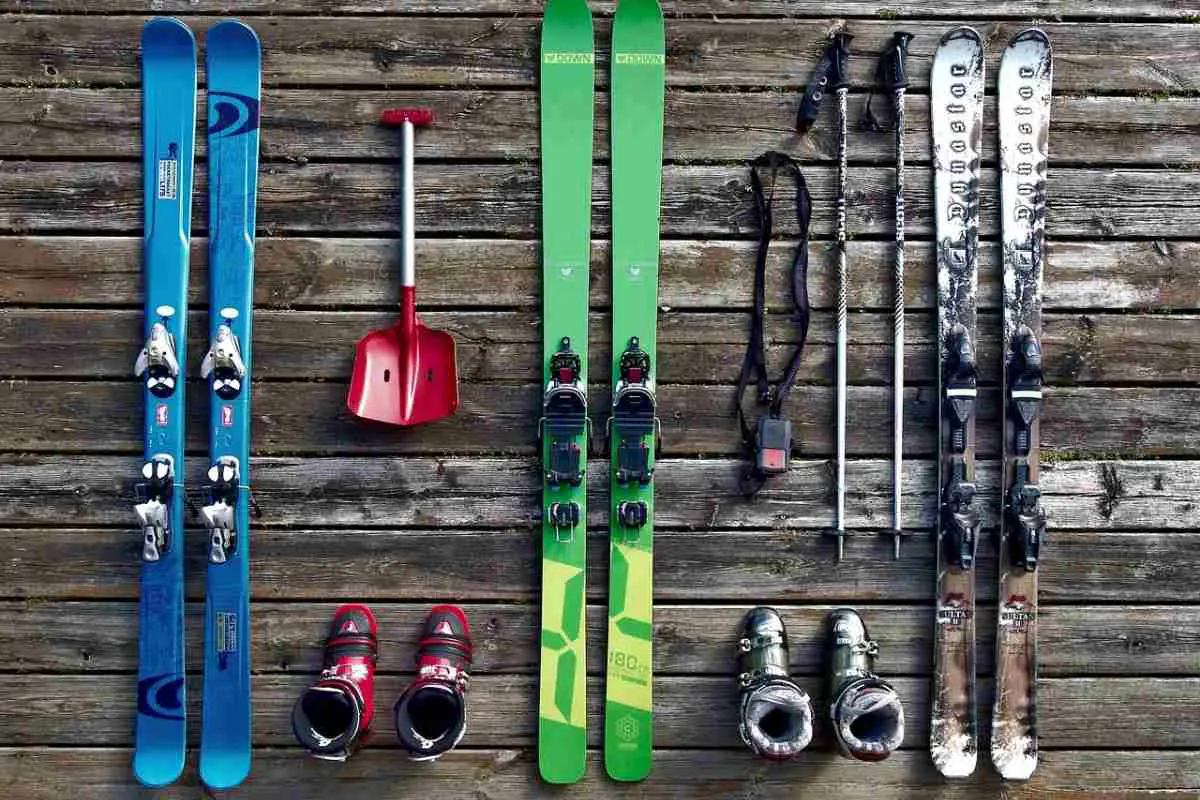 Three sets of skis, alongside poles, boots and a shovel demonstrate equipment needed for adventurous skiing. Photo by Tookapic from Pixabay