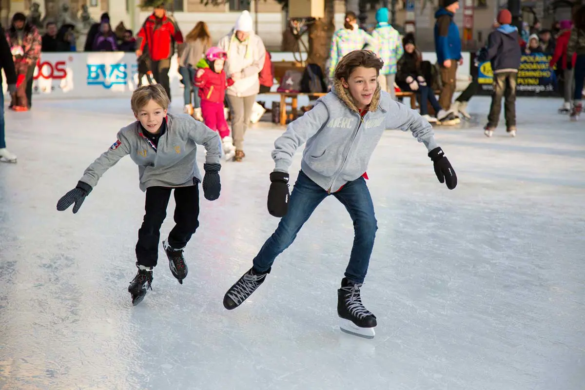 Kids Ice Skating on Outdoor Rink in Winter, Austria. Photo by Pech Frantisek, Pixabay.