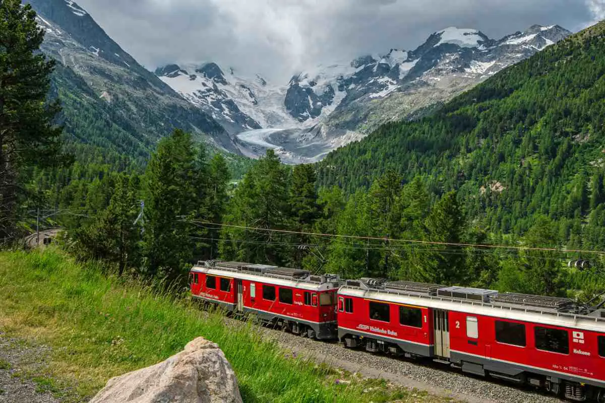 Red train travels through Bernina Pass, Poschiavo, Switzerland. Photo by Uwe Conrad from Unsplash