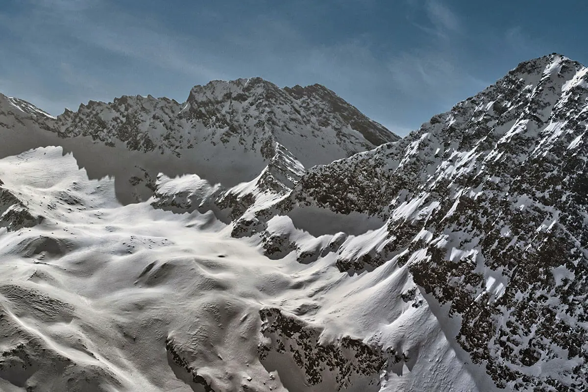 Schneebedeckte Bergkette unter blauem Himmel in Oberurgl, Österreich. Foto von Benjamin Behre, Unsplash.