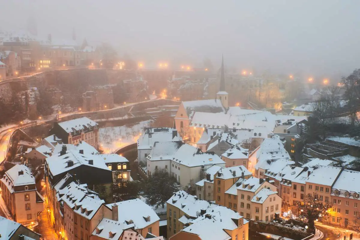 View of the rooftops of Luxembourg city on a misty snow day. Photo by Johny Goerend on Unsplash