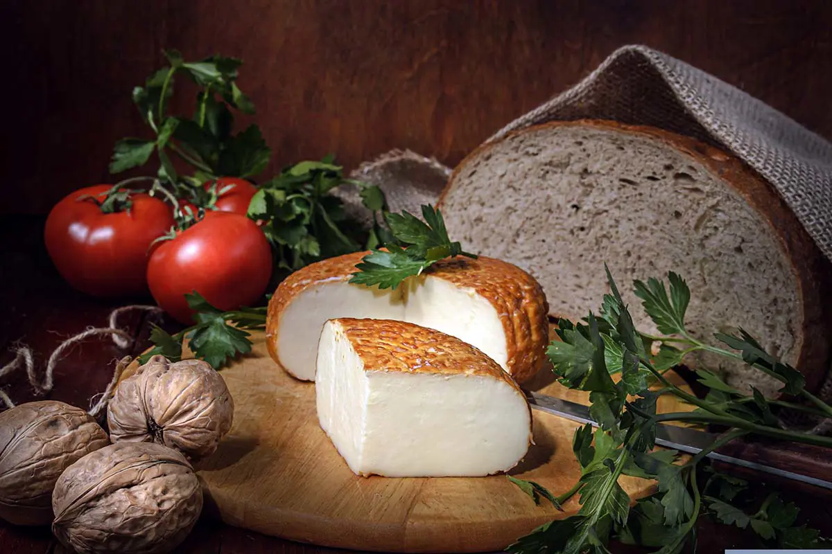 Artisan Cheese With Bread Tomatoes Walnuts and Parsley on Wooden Board. Photo by Dmitriy, Pixabay.