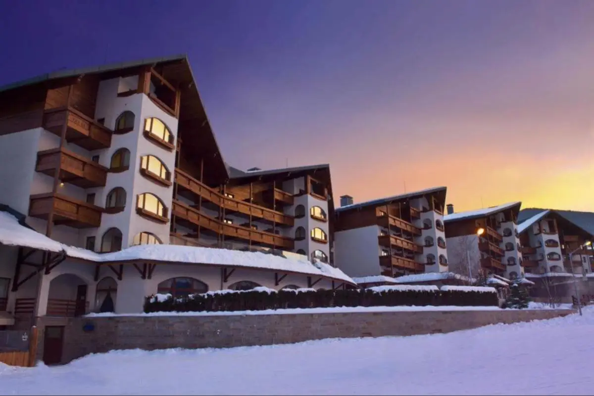 Kempinski Hotel Bansko, Bulgaria covered in snow at dusk as the sky turns purple