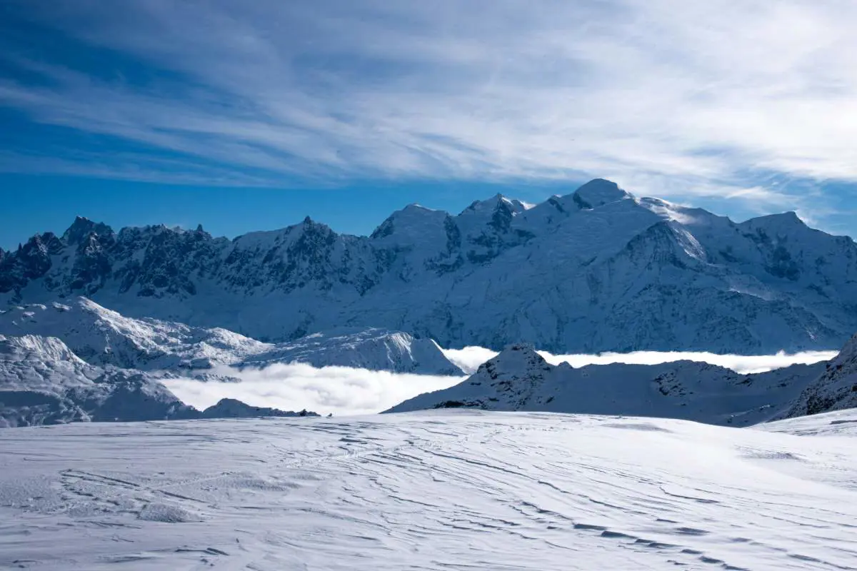 Blue Sky With Snow Capped Mountains at Flaine, Arâches La Frasse, France. Photo by Pierre Guerin on Unsplash.