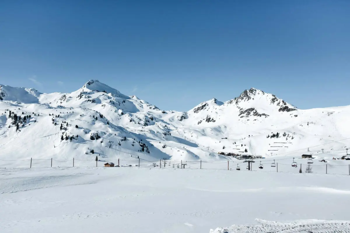 Schneebedeckte Berglandschaft mit Sesselliften in Obertauern, Österreich. Foto von Bernard Hermant auf Unsplash.