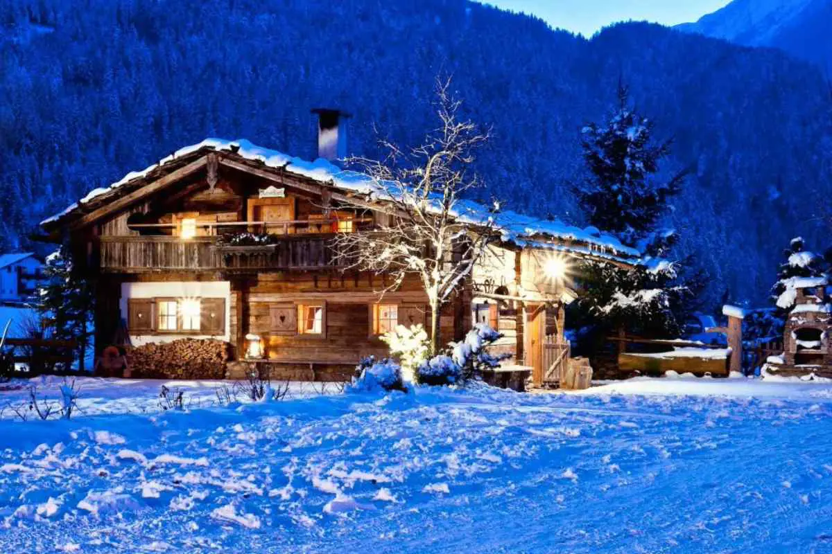 BRUGGER - L'ApartHotel illuminé dans la nuit enneigée, offrant un refuge chaleureux dans le paysage hivernal.