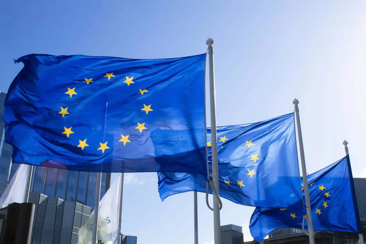 Three EU flags at full mast flying on a clear day. Photo by Alexandre Lallemand from Unsplash