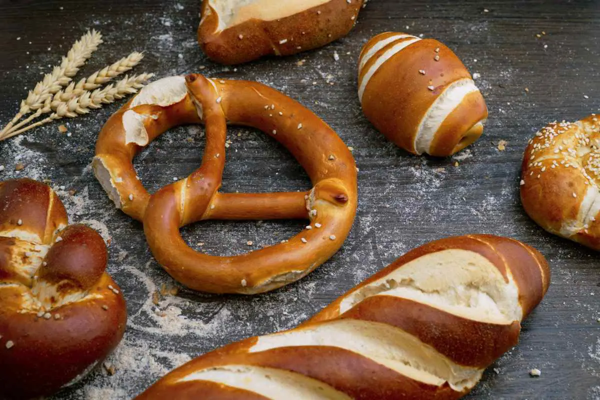Freshly baked Austrian bread and pretzels on a wooden table. Photo by Wesual Click on Unsplash.