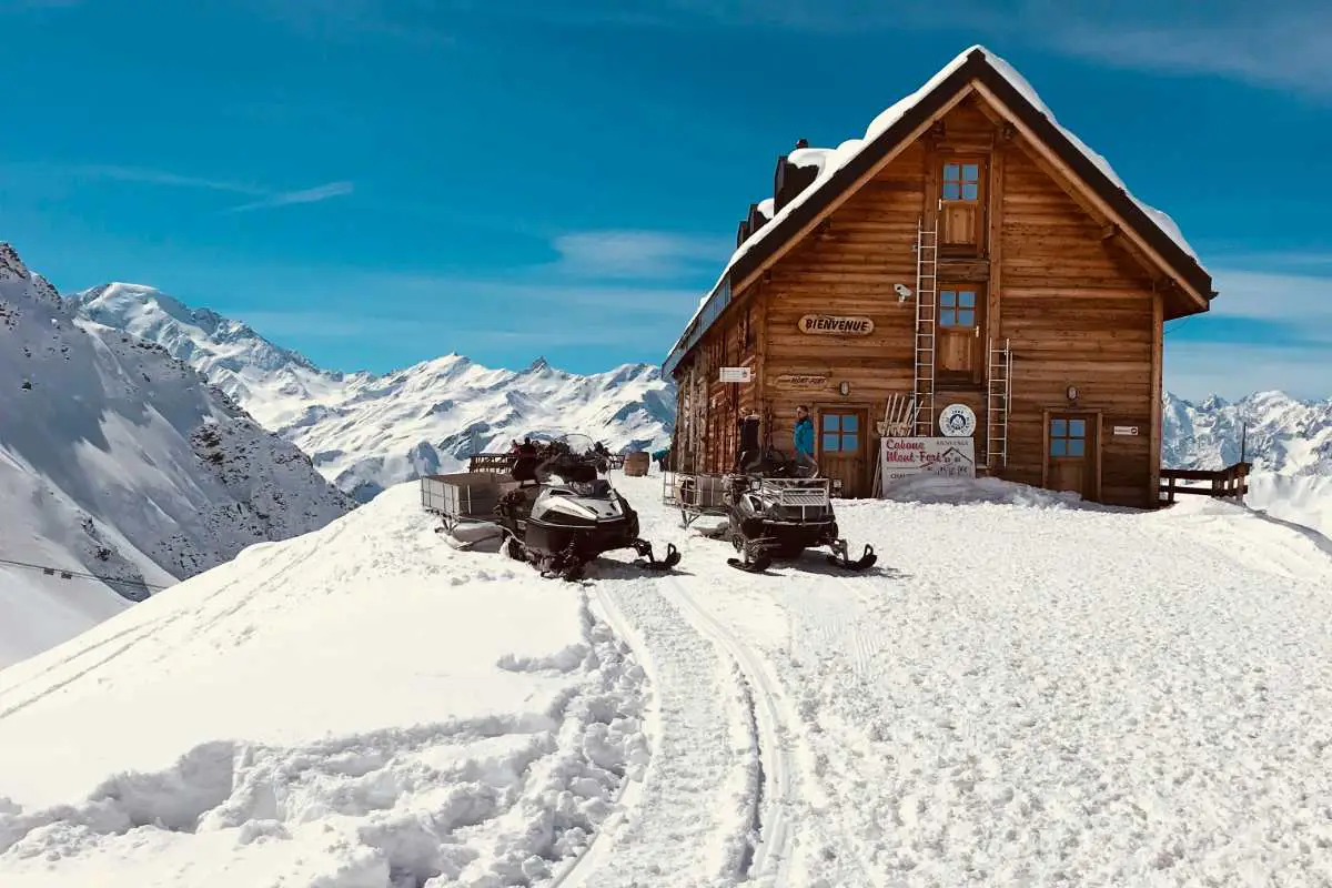 Two Skidoos Parked Up At A Mountain Chalter In Verbier Ski Resort, Switzerland. Photo By Maja Koppfeldt, Unsplash