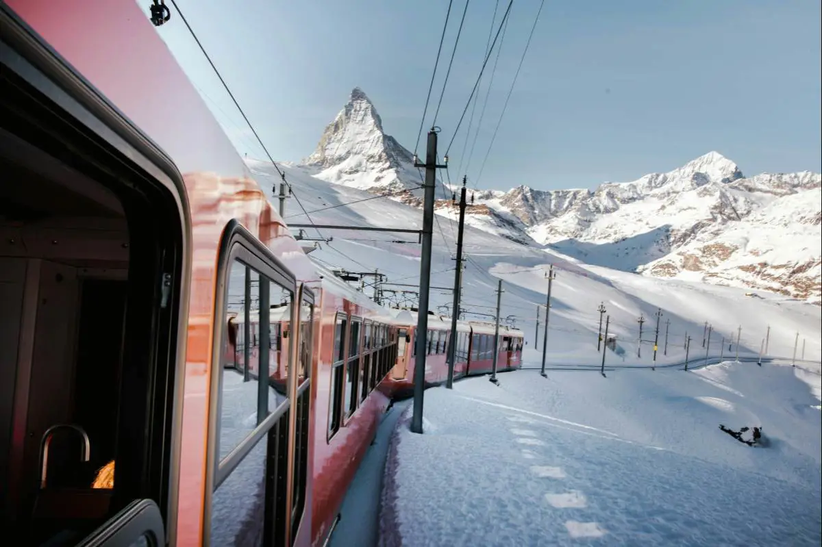 Train ride through the snow up to Zermatt ski resort in Switzerland with the Matterhorn in the background. Photo by Kevin Schmid from Unsplash