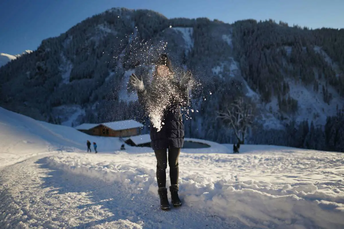 Woman throwing snow at the Wildpark Aurach, Wildparkweg, Aurach bei Kitzbühel, Austria. Photo by  Alexandr Voronsky from Unsplash