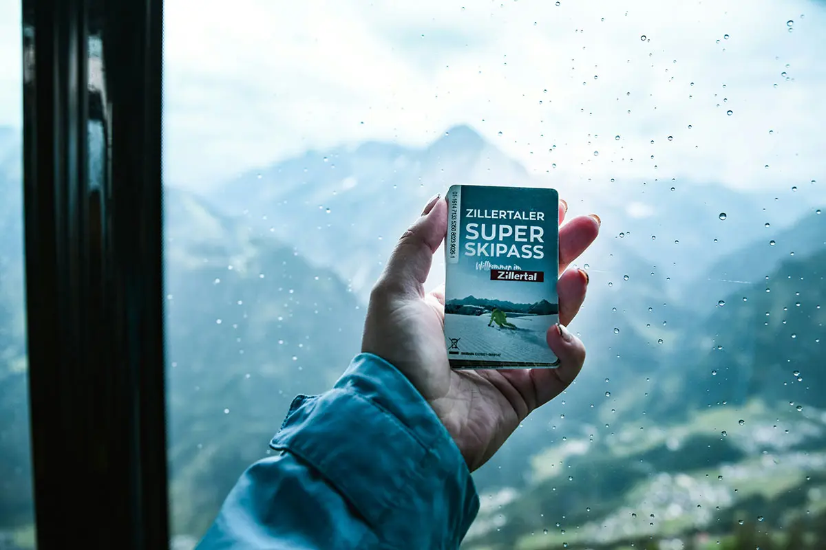 Personne tenant le Zillertal Super Skipass devant la fenêtre du Skilift à Mayrhofen, Autriche. Photo de Natalia Marcelewicz, Unsplash.