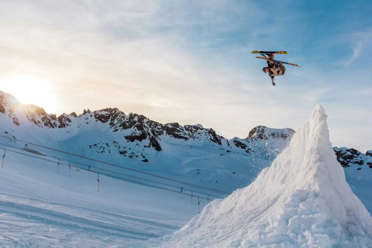 Freestyle skier flying off a jump mid piste in Austria. Photo by Jörg Angeli on Unsplash.