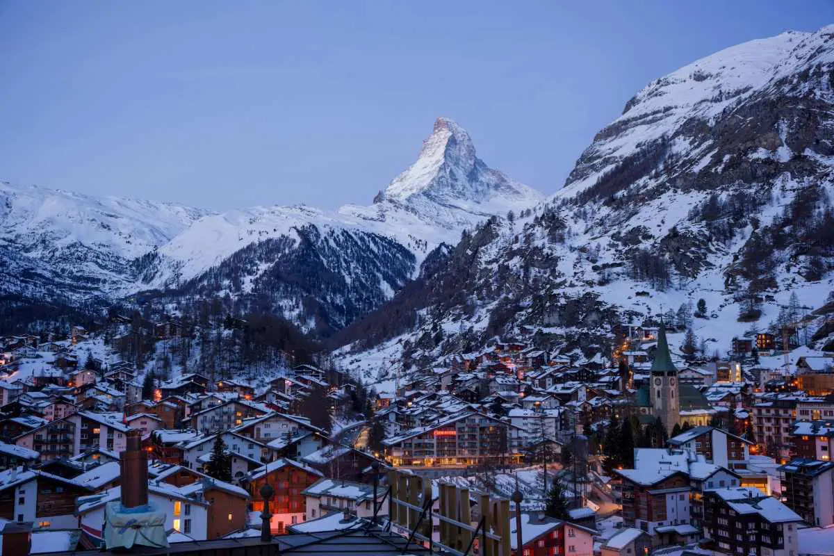 Vue du Cervin au crépuscule, couvert de neige, depuis la ville de ski de Zermatt, en Suisse. Photo d'Andrew Masters sur Unsplash.