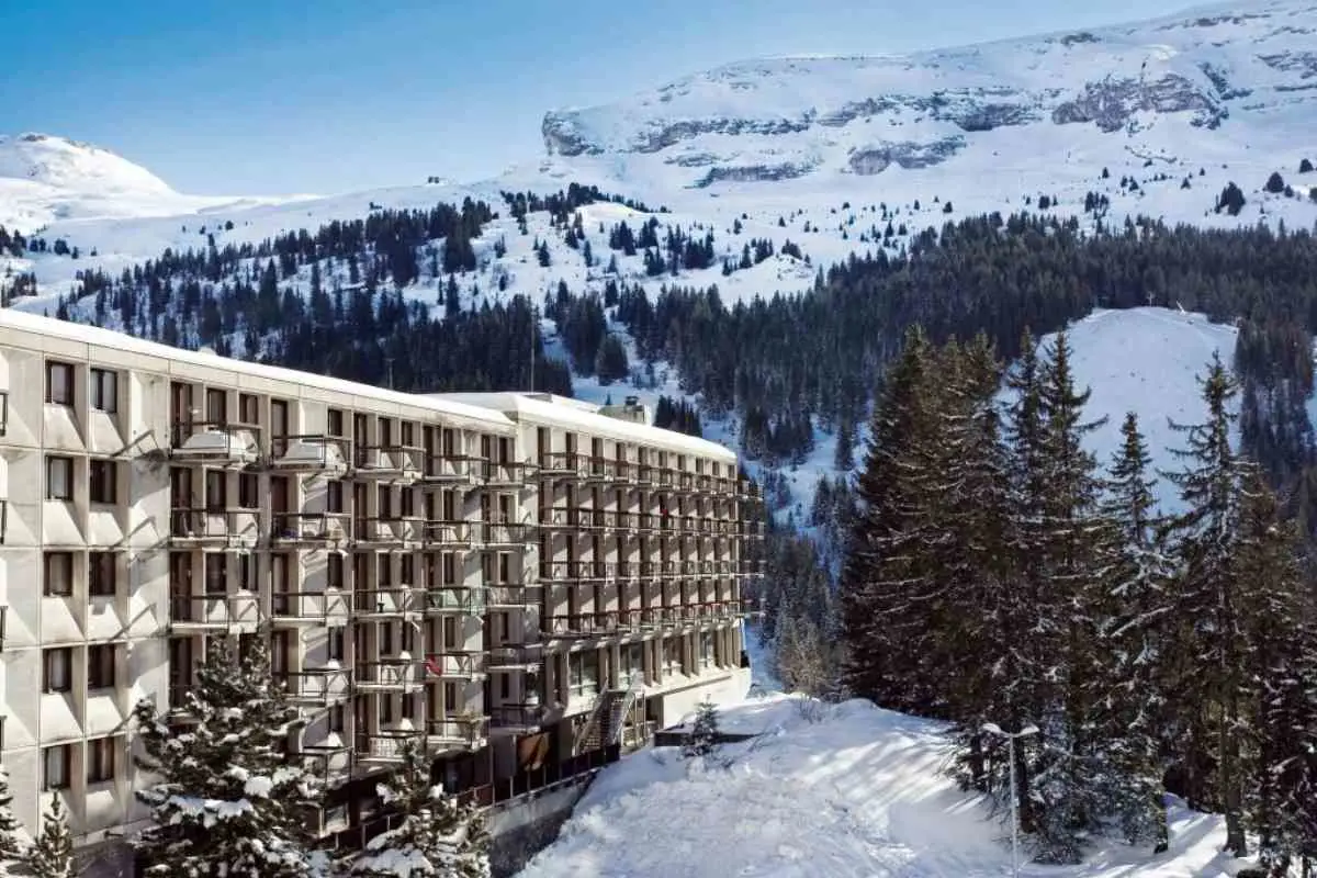 Back Of Hôtel Club Mmv Le Flaine With View Of Snow Capped Mountains In The Background.